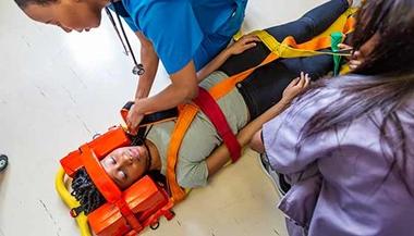 A woman is placed onto a stretcher.